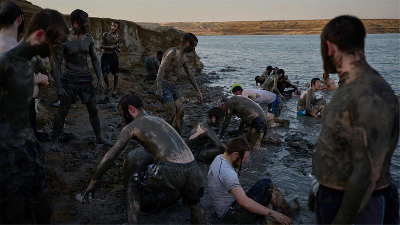 Ultraorthodoxe jüdische Männer bedecken sich am Toten Meer im Westjordanland mit Schlamm.