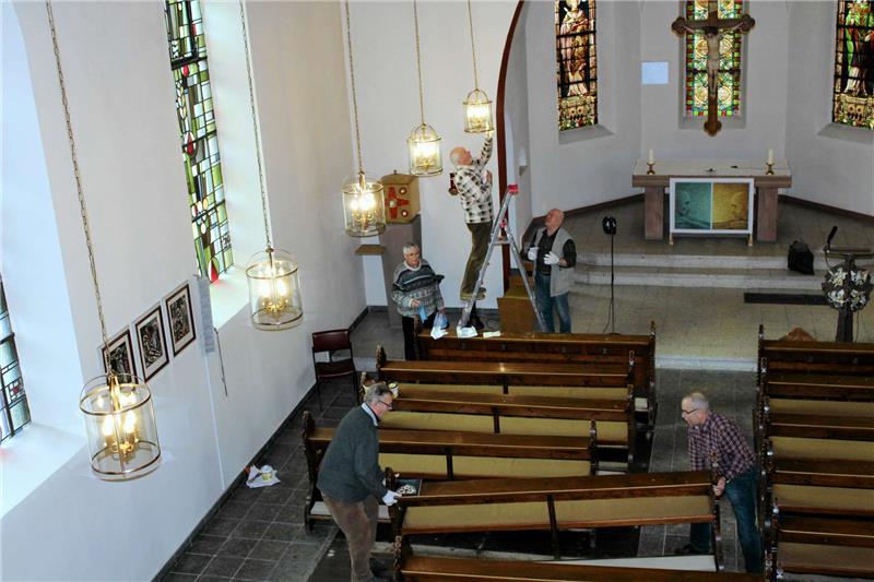 Um an die zwölf Hängeleuchten zu gelangen, müssen die Kirchenbänke abgeschraubt werden, damit die Leiter aufgestellt werden kann.  Foto: Seltmann