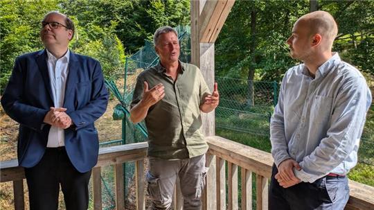 Umweltminister Christian Meyer (l.) und der SPD-Landtagsabgeordnete Christoph Willeke (r.) informieren sich bei Roland Pietsch zum Luchsprojekt an der Rabenklippe.