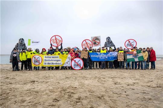 Umweltschützer und Insulaner demonstrieren am Weststrand von Borkum mit Bannern und Plakaten gegen die geplante Erdgasförderung.