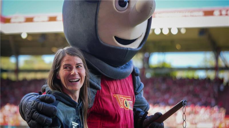 Union-Trainerin Marie-Louise Eta wird von Club-Maskottchen Ritter Keule umarmt. 
