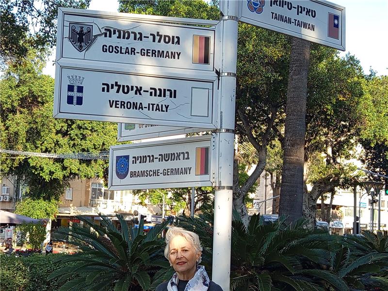 Goslars israelische Partnerstadt bangt um die Geiseln Unsere Autorin Régine Sturm vor Schildern mit den Partnerstädten von Raanana.