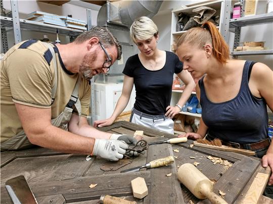 Unter Anleitung von Tischler Normen Schur (v.li.) arbeiten Birte Holtmann und Maike Lichatz die Tür aus dem Zwischengeschoss des Hopfenspeichers auf. Sie stammt aus dem Jahr 1672.  Fotos: Demiran