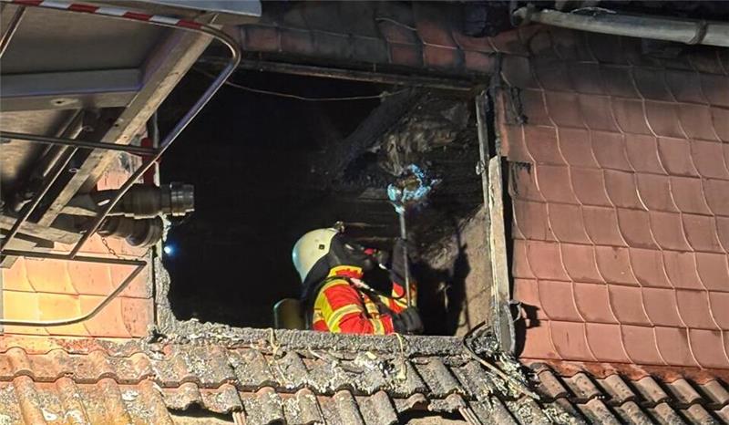 Unter Atemschutz sucht ein Mitglied der Freiwilligen Feuerwehr nach Glutnestern.