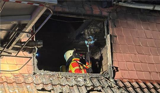 Unter Atemschutz sucht ein Mitglied der Freiwilligen Feuerwehr nach Glutnestern.