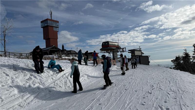 Mehr als einen Meter Schnee: Braunlage meldet Rekordzahlen Das Foto zeigt Snowboardfahrer unterhalt eines Aussichtsturms.