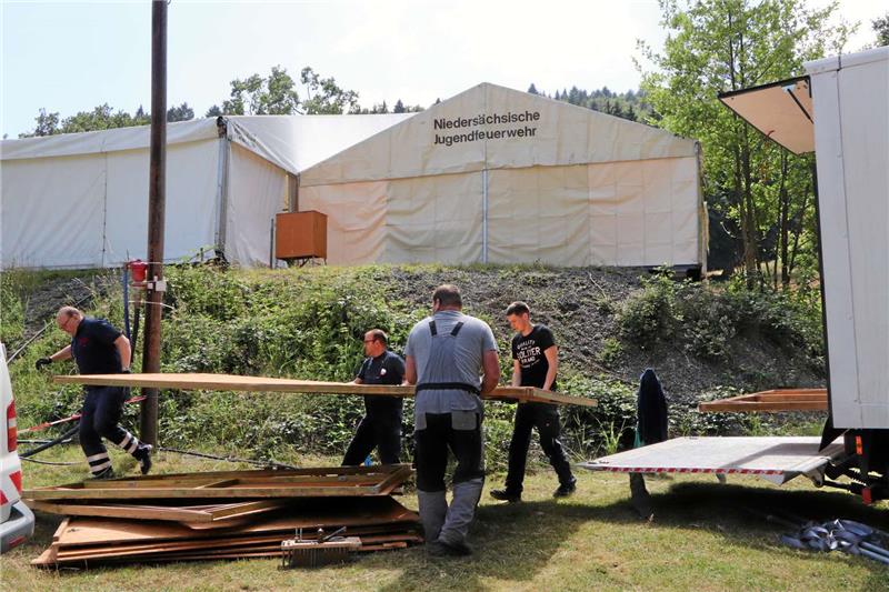 Unterhalb des großen Veranstaltungszelts bauen Helfer die Grillbude auf, an der sich bei Wurst und Cola Teamer und Jugendliche stärken können.