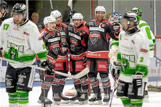 Unterschiedliche Gefühlswelten: Während die Harzer Falken das 2:0 durch Filip Mrava (M.) feiern, schleichen die Spieler der Wunstorf Lions vom Eis. Foto: Drechsler