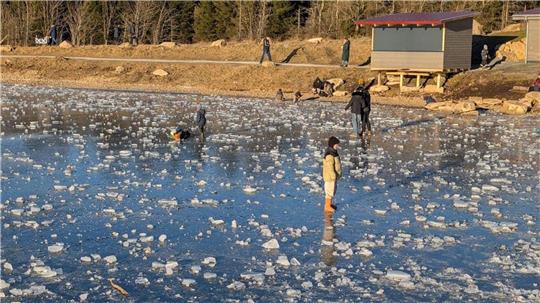 Das Foto zeigt Menschen auf einem zugefrorenen See.