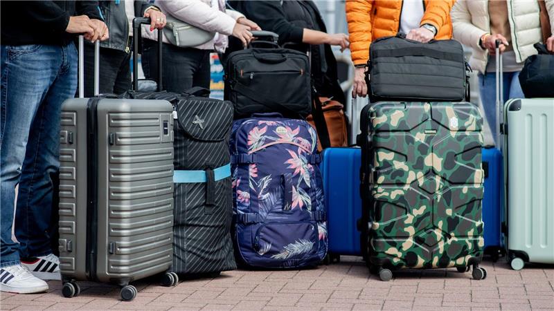 Urlauber mit Gepäck vor einer Fähre nach Norderney