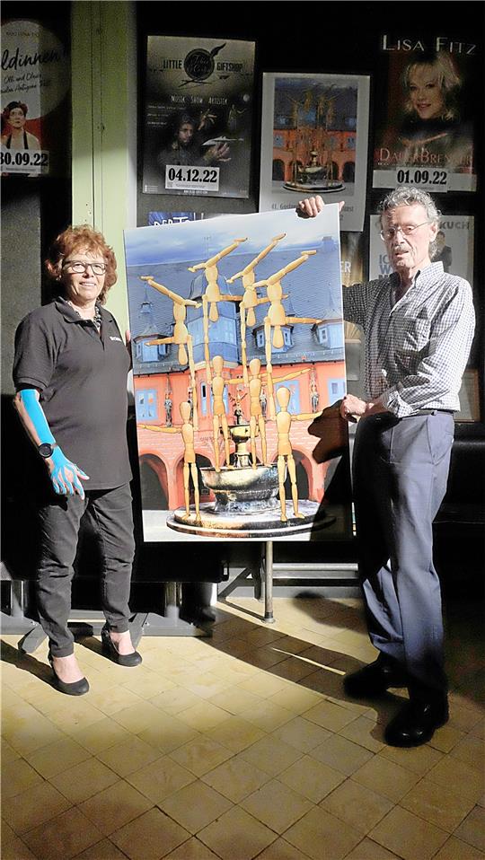 Uwe Siegmeier überreicht Renate Lucksch ein Geschenk fürs Kraftwerk: sein Plakatmotiv als Bild auf Leinwand.