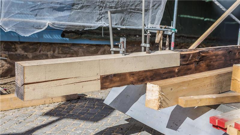 Verkohlte Balken werden durch frisches Harzer Holz ersetzt, um die Statik der Kirche zu sichern.