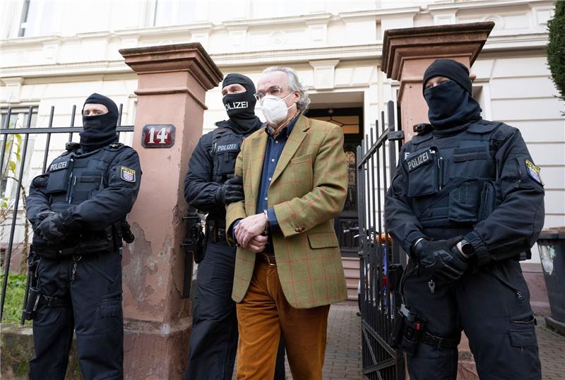 Prinz Reuß und die Putschpläne: Reichsbürgerprozess beginnt Vermummte Polizisten führen im Dezember 2022 Heinrich XIII. Prinz Reuß in Frankfurt am Main zu einem Polizeifahrzeug.