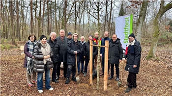 Eine Gruppe Menschen steht im Wald.