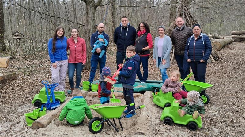 Vertreter der Volksbank, Vorstand und Erzieherinnen und die Kinder vom Waldkindergarten beim „Einweihen“.