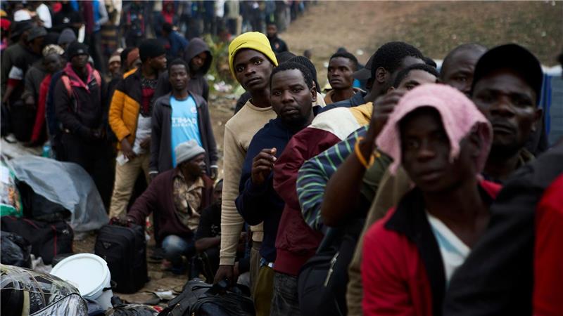 Vertriebene Migranten stehen in Durban in Südafrika vor einer Abschiebeeinrichtung Schlange.
