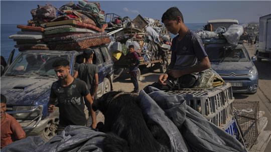 Vertriebene Palästinenser tragen ihre Habseligkeiten, während sie aus dem nördlichen Gazastreifen entlang der Küstenstraße in Richtung Süden fliehen, nachdem Israel eine erweiterte Operation in Gaza-Stadt angekündigt hat. 