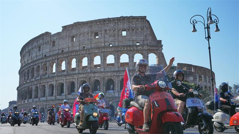 Vespa-Fans fahren am Kolosseum vorbei.