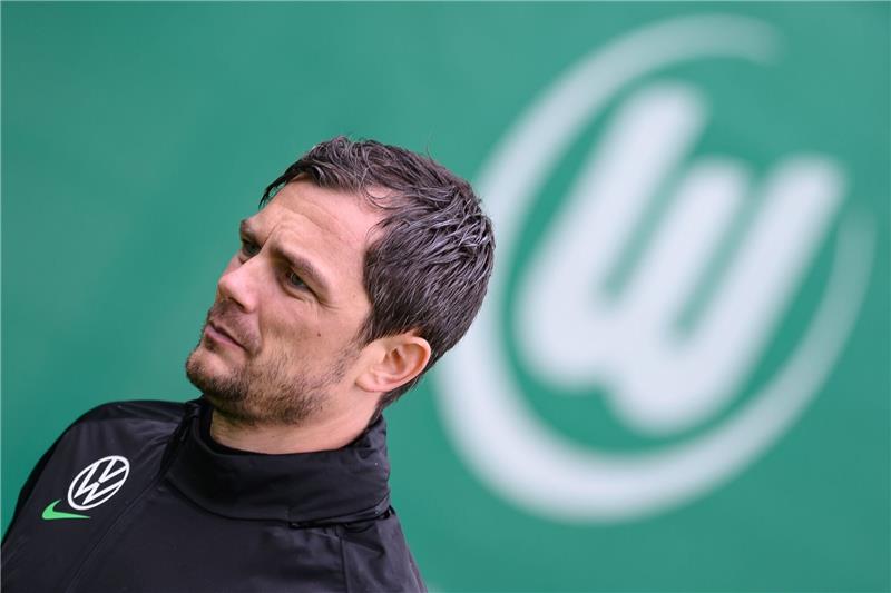VfL Wolfburgs Sportdirektor Marcel Schäfer  steht auf dem Feld.