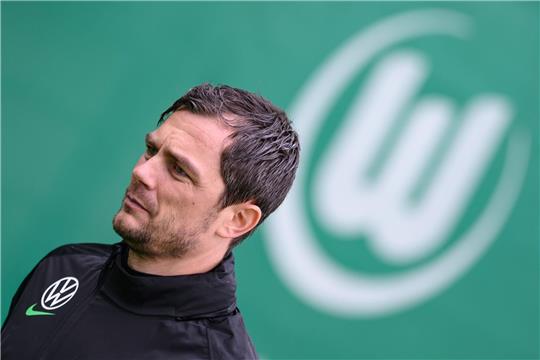 VfL Wolfburgs Sportdirektor Marcel Schäfer  steht auf dem Feld.