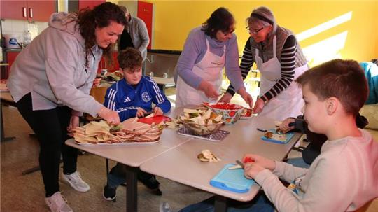 Viele Helfer sind aktiv, um das gesunde Frühstück in der Grundschule Astfeld vorzubereiten.