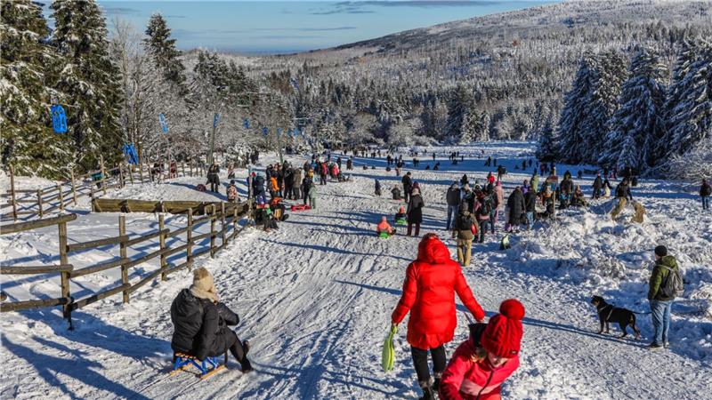 Menschen fahren Schlitten oder laufen auf der Rodelbahn