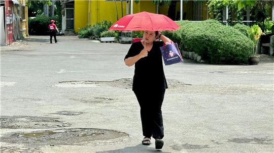 Viele schützen sich mit Schirmen vor der Sonne.