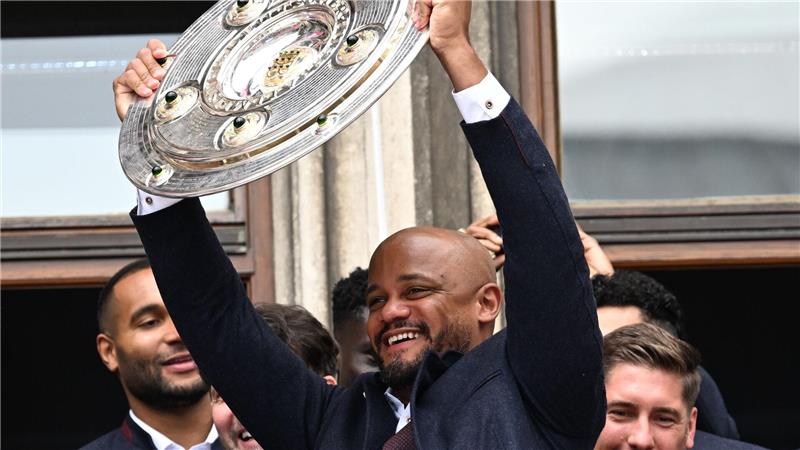 Kompany kontra Hoeneß: Zwei Bessermacher im „Pott“-Duell Vincent Kompany reckt die Meisterschale auf dem Münchner Rathausbalkon in die Höhe. (Archivbild)
