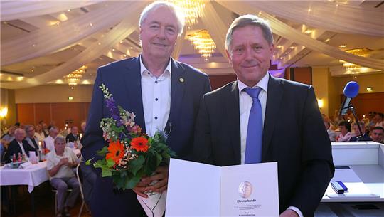 Volksbank-Vize-Aufsichtsratschef Dr. Christian-Peter Frees (links) wird durch durch Mario Kießling mit der Goldenen Ehrennadel des Genoverbandes ausgezeichnet.
