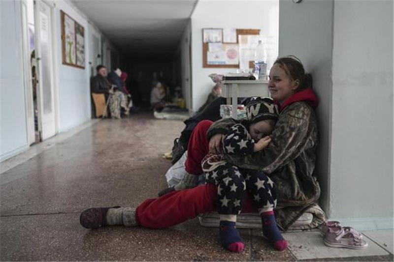Gefangen im Kessel von Mariupol Voller Trauer und Verzweiflung: Anastasia Erashova umklammert im Flur eines Krankenhauses in Mariupol ihr Kind. Zwei weitere Kindervon ihr wurden während des Beschusses der Stadt getötet. Foto: Evgeniy Maloletka/dpa