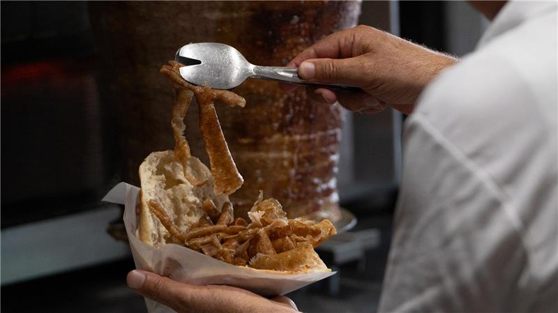 Döner-Streik in Großfabrik: Bleiben jetzt die Spieße stehen? Vom Spieß ins Brot: Ein Mann bereitet einen Döner zu. (Archivbild)