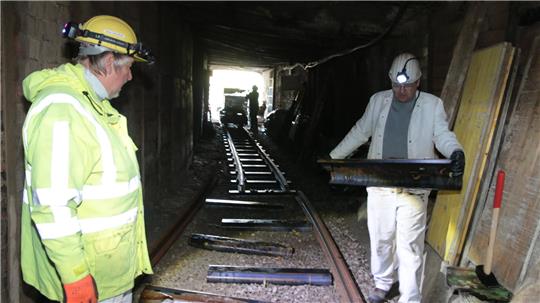 Von Hand muss jede einzelne Bahnschwelle in den Stollen getragen werden. Sie sind aus Stahl gefertigt. Eine Schwelle wiegt rund 20 Kilogramm.