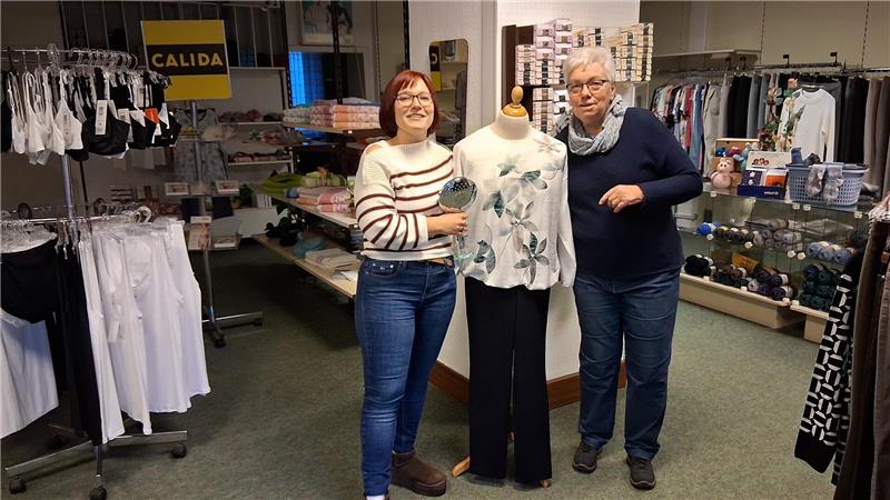 Kristin Eitler und Regina Strübig stehen neben einer angezogenen Schaufensterpuppe im Wäschehaus.