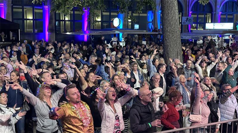 Jubelnde Menschen vor einer Bühne.