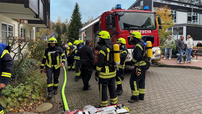 Das Foto zeigt mehrere Feuerwehrleute vor einem Feuerwehrwagen.