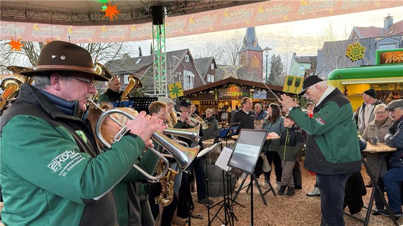 Das Foto zeigt eine Blaskapelle mit Dirigenten auf einem Marktplatz.