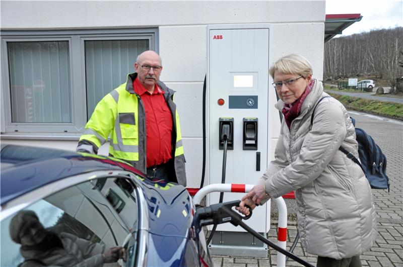 Voll unter Strom: Bernhard Olbrich und seine Firmenwagen-Flotte Vor dem Haus legt die Ortsbürgermeisterin Hand an: Barbara Eberhardt testet unter den Augen von Firmenchef Bernhard Olbrich den Schnelllader, der mit einer Leistung von 120 Kilowatt aufwartet. Foto: Heine