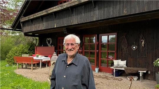 Das Foto zeigt einen Mann vor einem Haus.