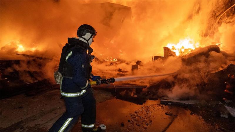 Vor den Flammen: Ein Feuerwehrmann löscht nach dem russischen Luftangriff einen Brand in einem Wohngebiet.
