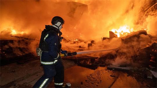 Vor den Flammen: Ein Feuerwehrmann löscht nach dem russischen Luftangriff einen Brand in einem Wohngebiet.