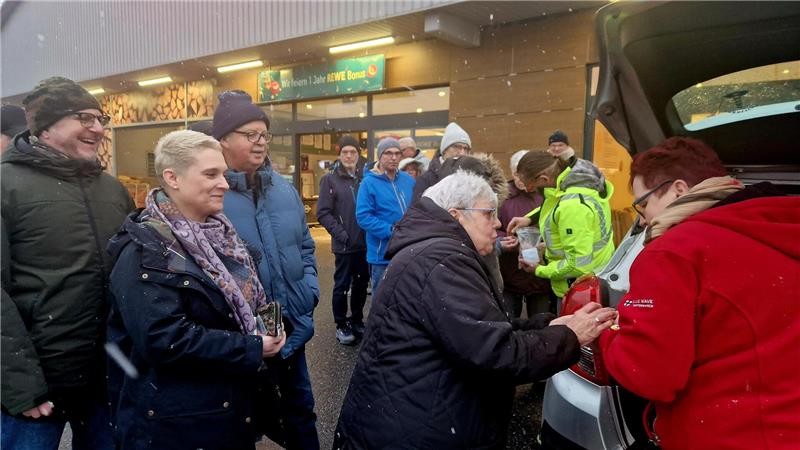 Zahlreiche Menschen warten darauf, Glücksschweinchen kaufen zu können.