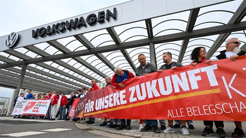 Vor der Betriebsversammlung von VW in Zwickau demonstrieren Beschäftigte am Werkstor.