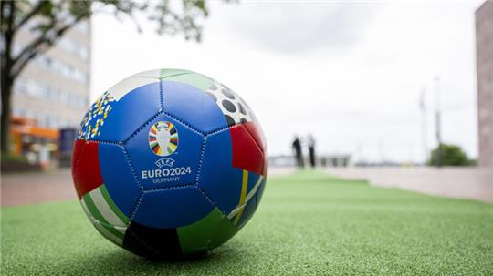 Vor der EM liegt ein Fußball in Dortmund auf dem ersten Teppichabschnitt. Während der Europameisterschaft verläuft eine Kunstrasen-Strecke zur Orientierung der Besucher vom Hauptbahnhof bis zum Stadion in Dortmund.