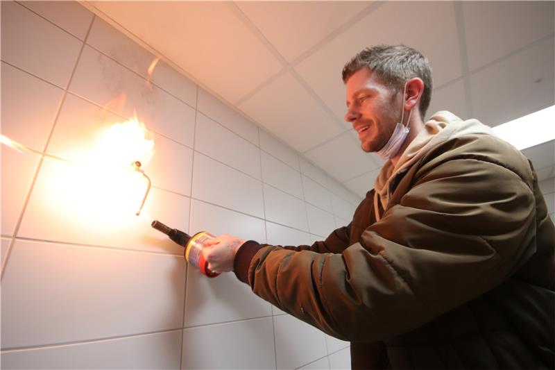 Vor der Probenentnahme flammt Dennis Bucholtz vom Wassertechnologischen Institut Wolfenbüttel, das mit der Analyse betraut ist, die Wasserleitung ab. Fotos: Gereke
