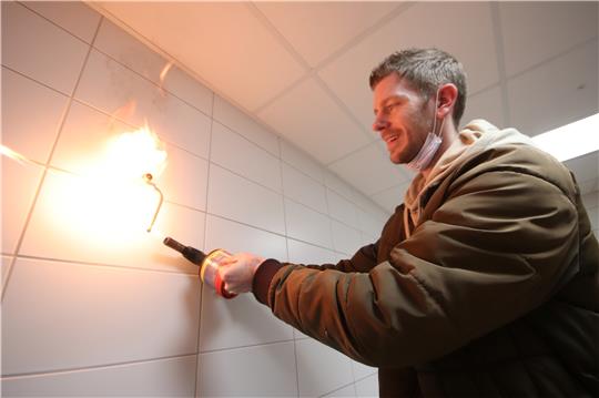 Vor der Probenentnahme flammt Dennis Bucholtz vom Wassertechnologischen Institut Wolfenbüttel, das mit der Analyse betraut ist, die Wasserleitung ab. Fotos: Gereke