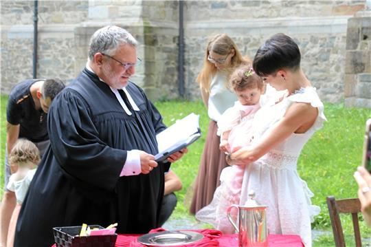 Vor der St.-Salvatoris-Kirche tauft Pastor André Dittmann fünf neue Gemeindeglieder in unterschiedlichem Alter. Foto: Skuza
