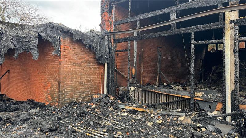 Vor der zerstörten Aula zeigt sich das Ausmaß des Brandes deutlich. (Archivbild)