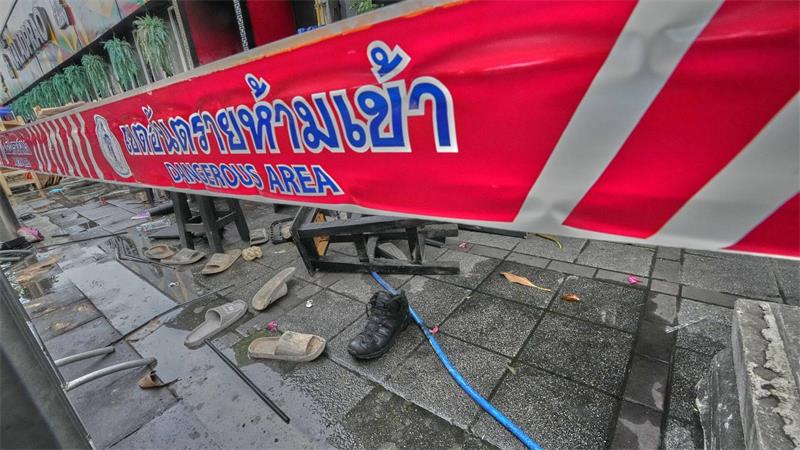 Vor einem Pub in Bangkok liegen nach einem Brand verstreute Schuhe.