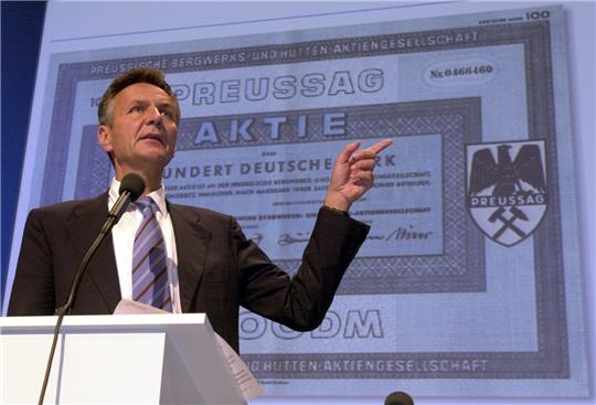 Vor einer historischen Aktie gestikuliert  2002 der damalige Preussag-Vorstandsvorsitzende Michael Frenzel in Hannover. Im selben Jahr firmierte sich die Preussag AG um in TUI. Foto: dpa/Hollemann
