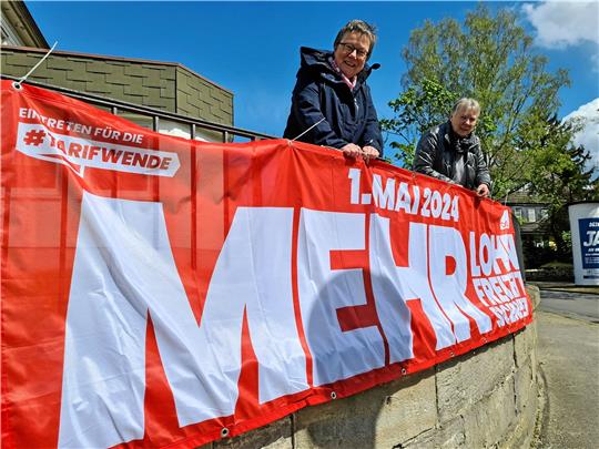 Vorbereitungen: Susanne Ohse und Rosi Bergmann hängen das Banner für den 1. Mai am DGB-Gebäude in der Astfelder Straße auf. Foto: Kempfer